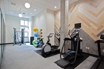 a gym with weights and other exercise equipment in a room with wooden walls